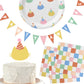 Party supplies including cake toppers, plates, and napkins with colorful designs on a white background.